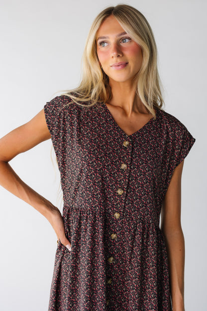 Close view of a woman wearing a black floral button down dress with short sleeves