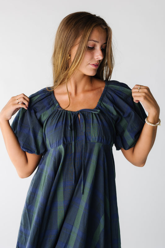 Close view of a woman wearing a blue and green plaid dress with scoop neckline