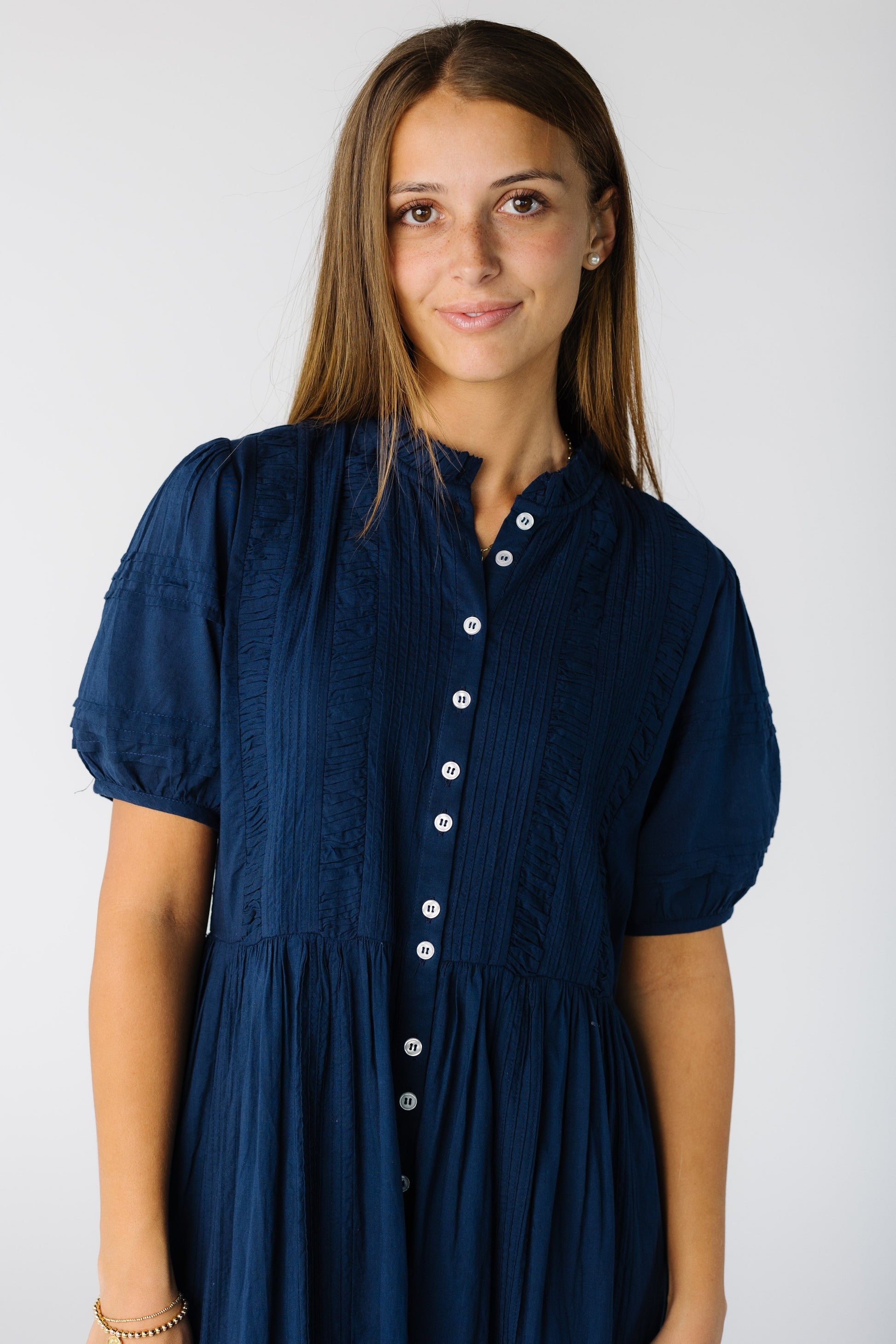Close view of a woman wearing a navy button down dress with short sleeves