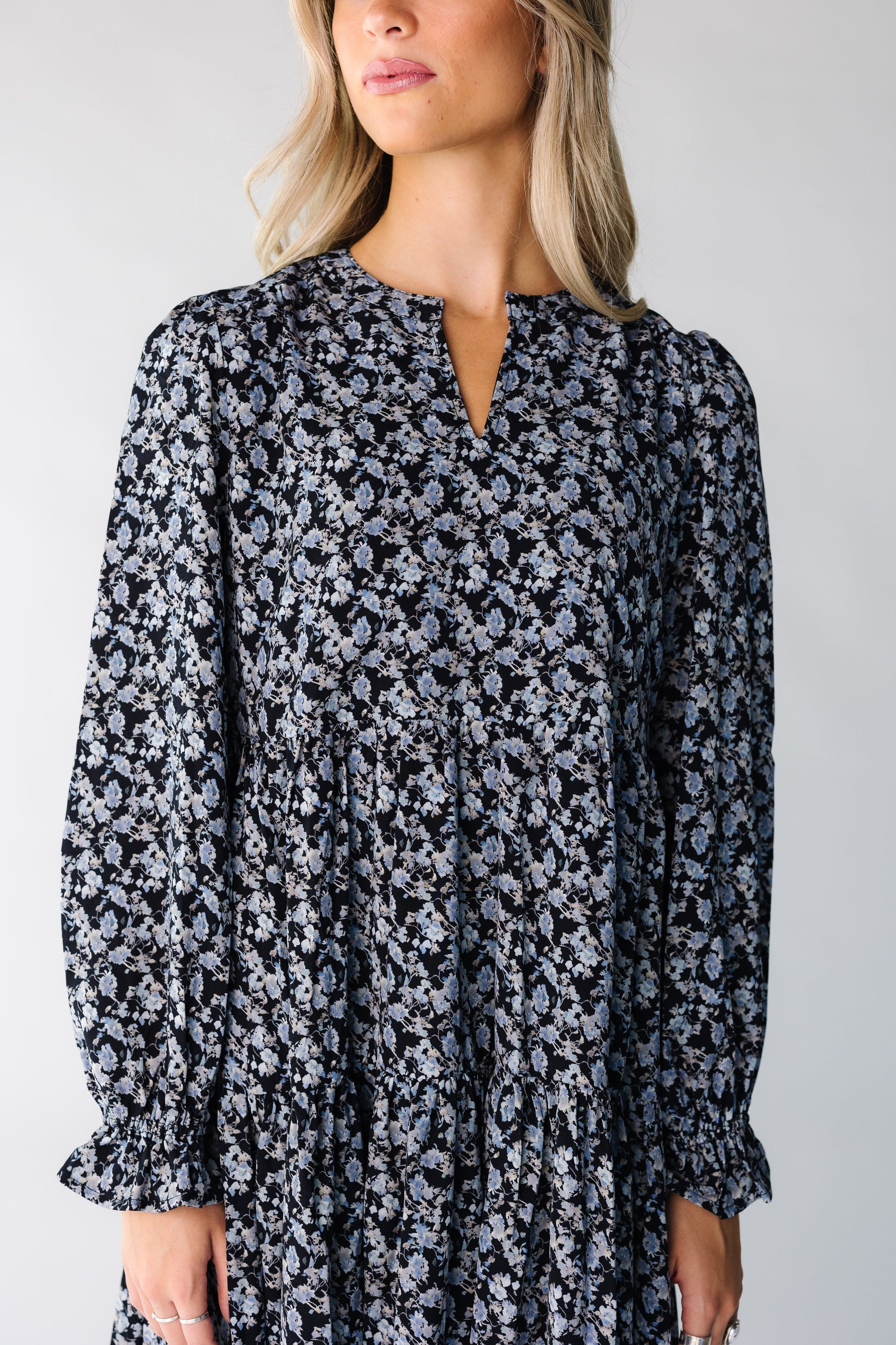 Close view of a woman wearing a blue floral dress with long sleeves
