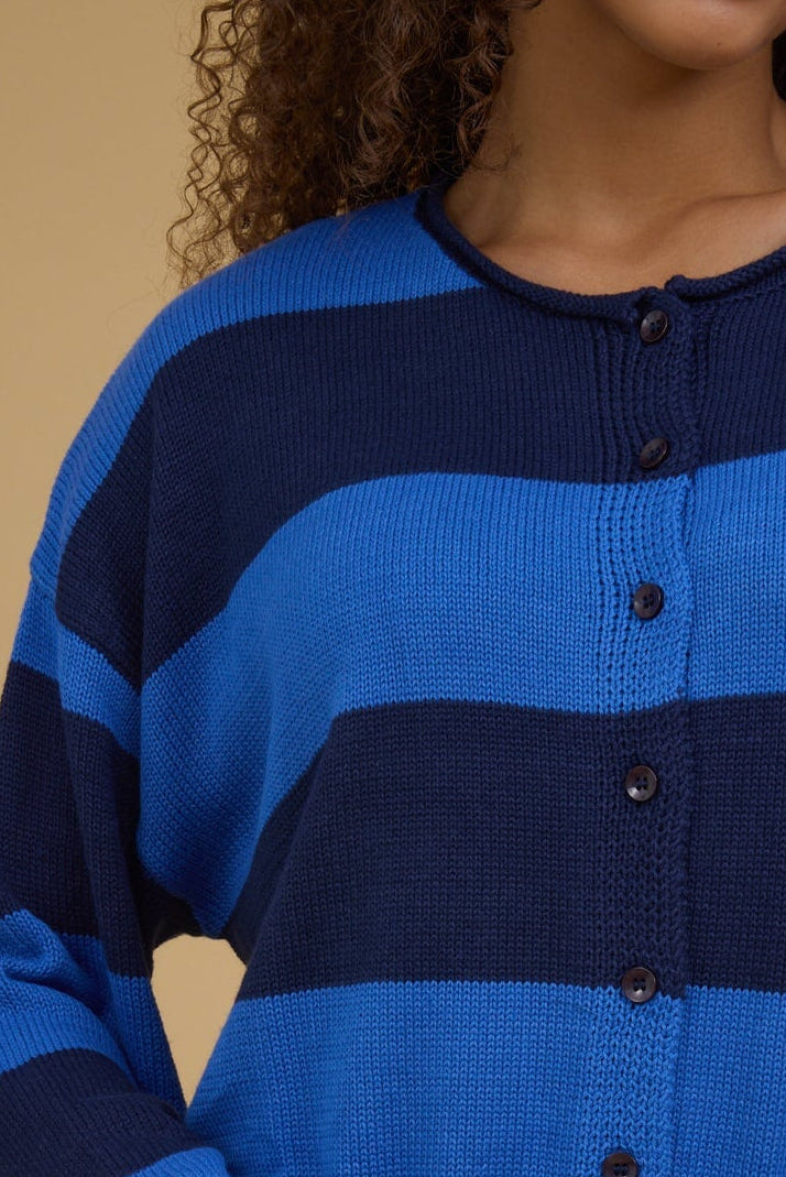 Close up of a teen girl wearing a blue & navy wide stripe, button down cardigan.