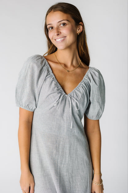 Woman wearing a narrow navy stripe dress with a V-neckline and short puff sleeves