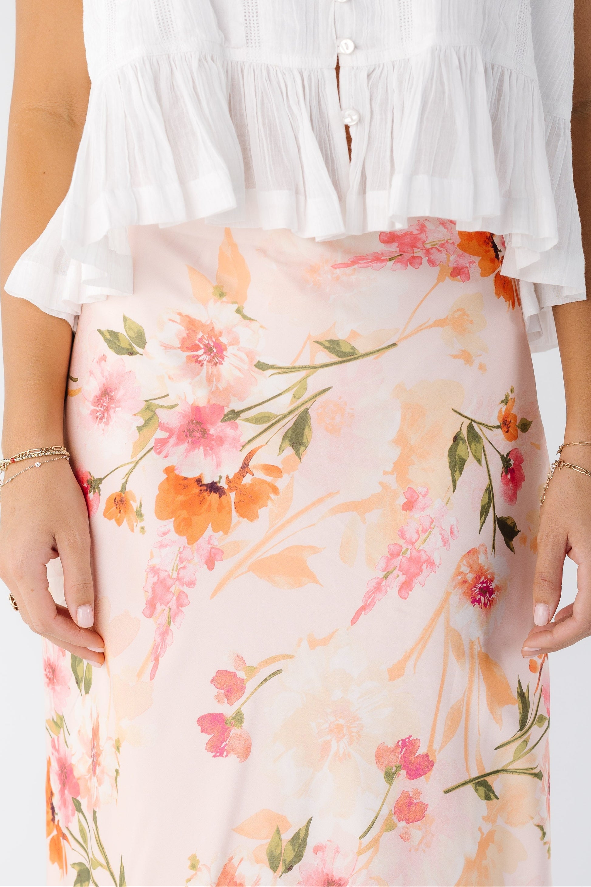 Close view of a young woman wearing a pink floral skirt.