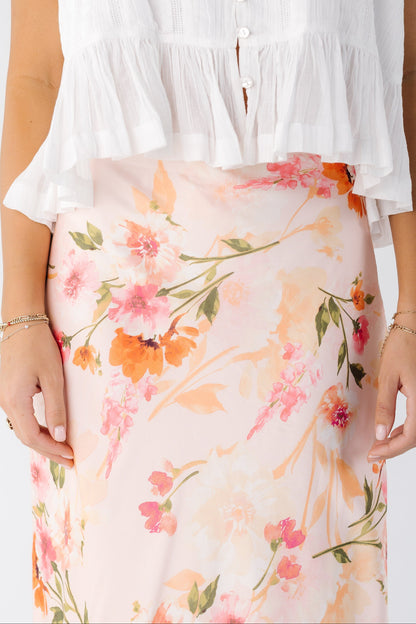 Close view of a young woman wearing a pink floral skirt.