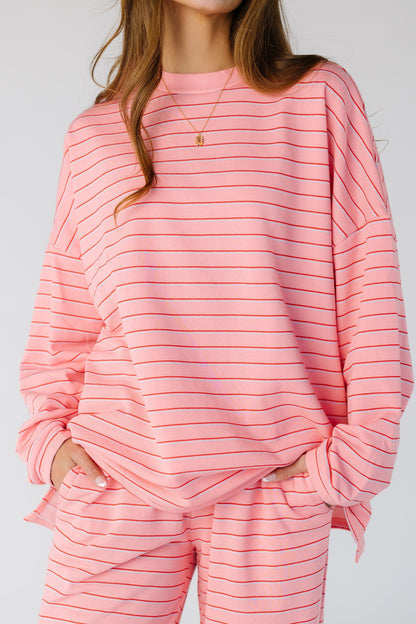Close view of a woman wearing a pink lounge set in pink with pockets