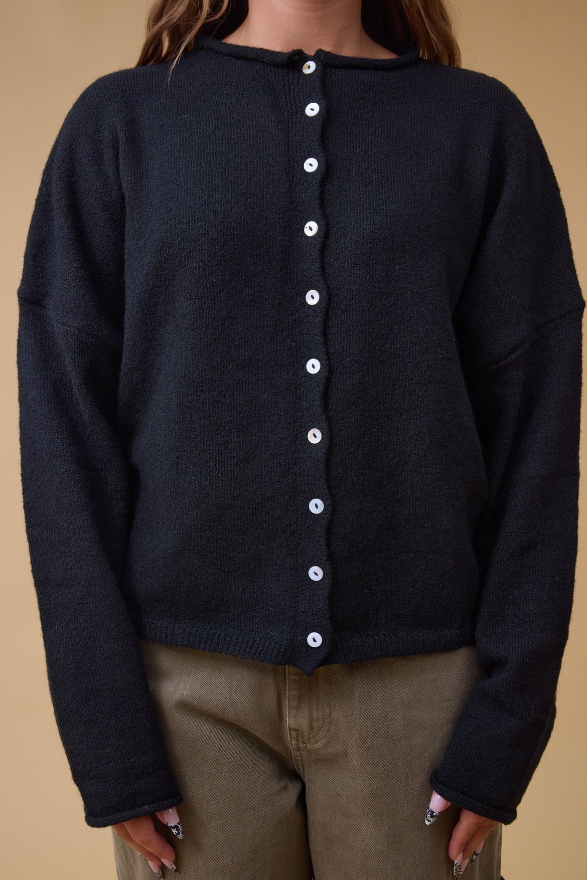 Loose fitting button down cardigan with long sleeves and a rolled collar.
