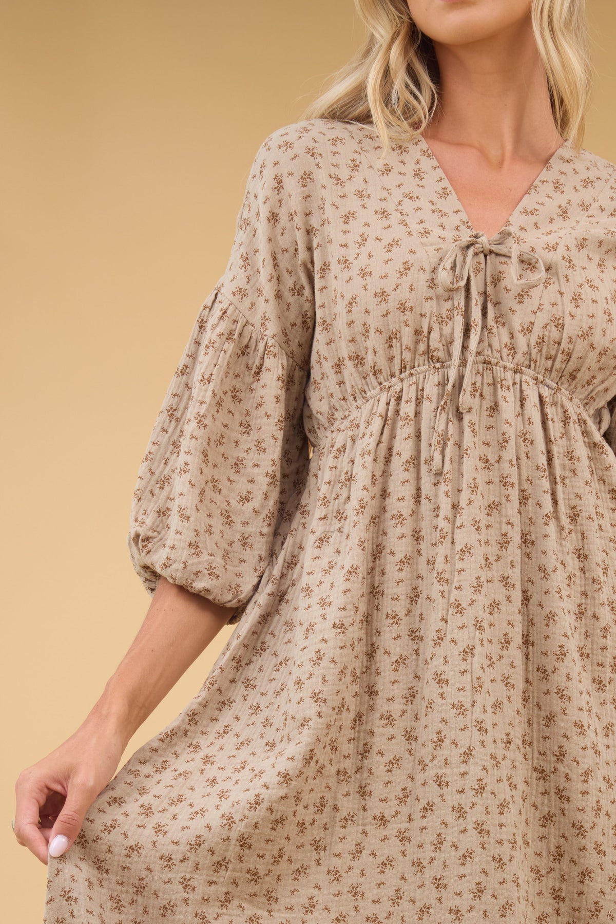 Close view of a young woman wearing an empire waist V-neckline and half length sleeves.