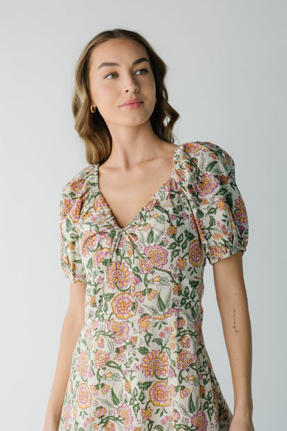 Close view of cream print dress with short puff sleeves and V-neckline