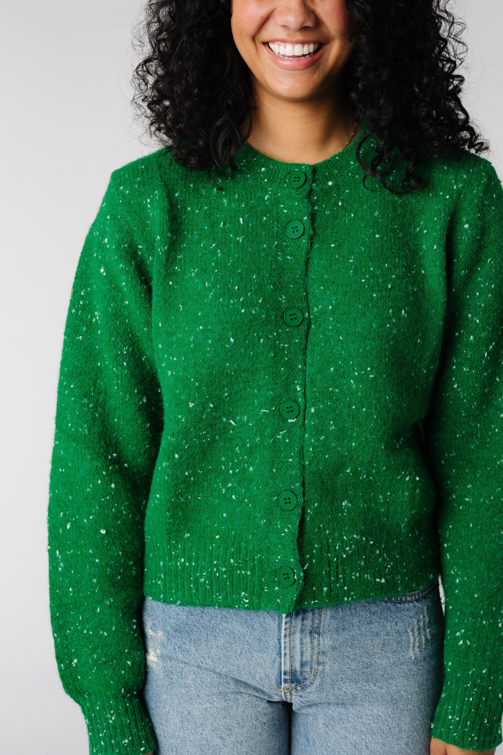 Close view of green button cardigan