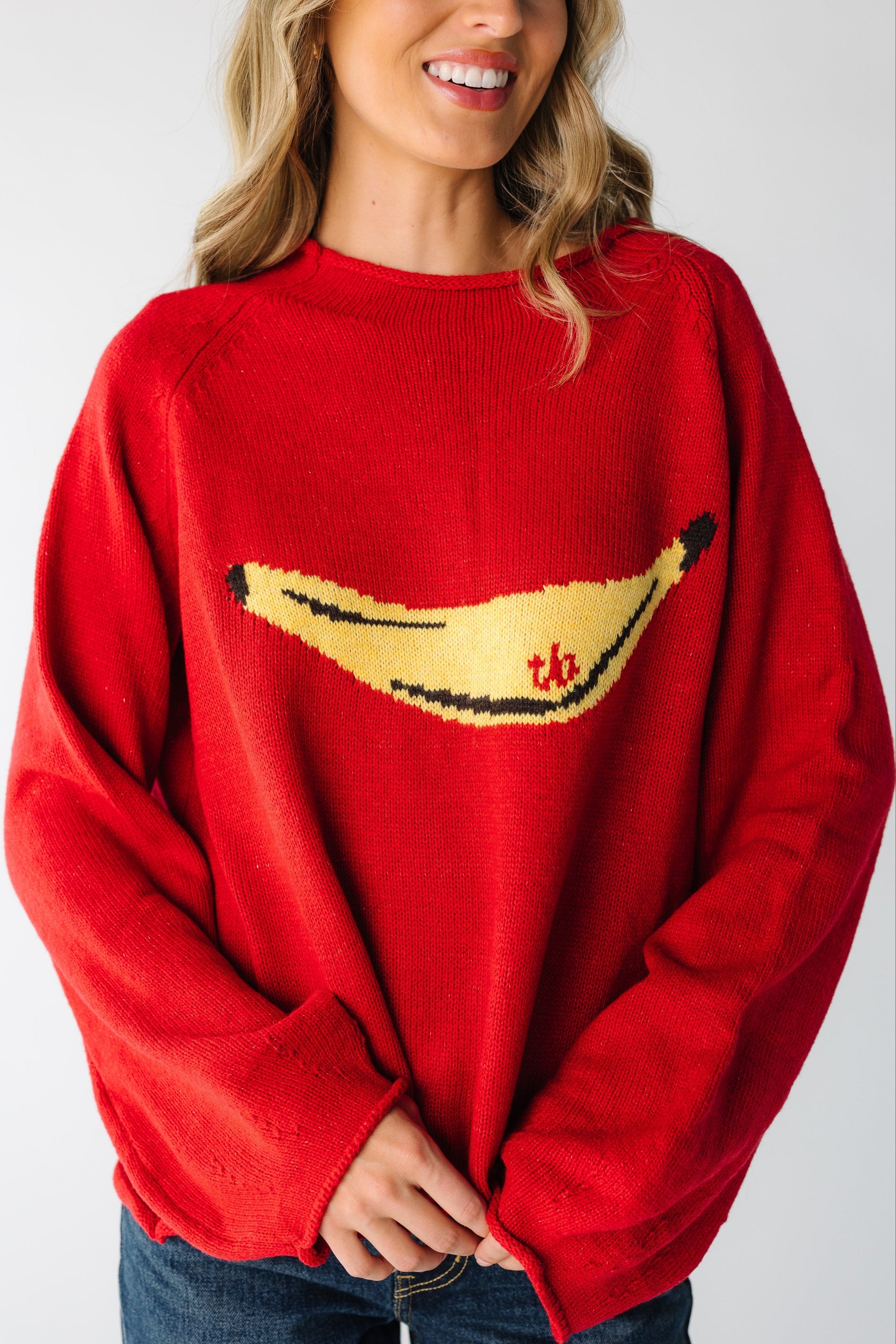 Woman wearing a loose fitting sweater with large yellow banana graphic