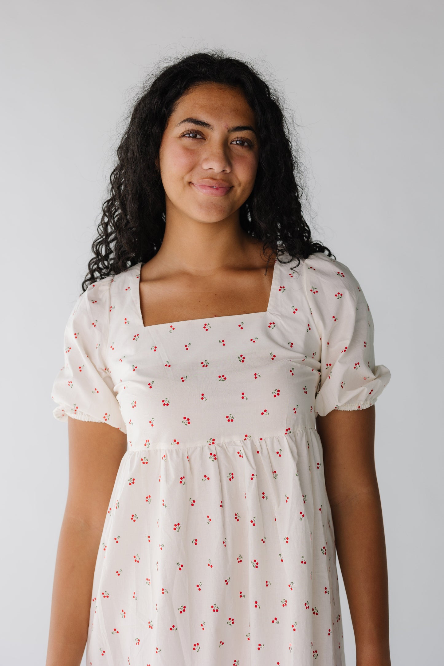 Close view of cherry print dress with square neckline