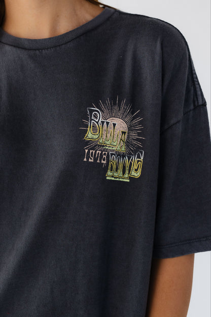 Close up view of a woman wearing a Billabong graphic tee.