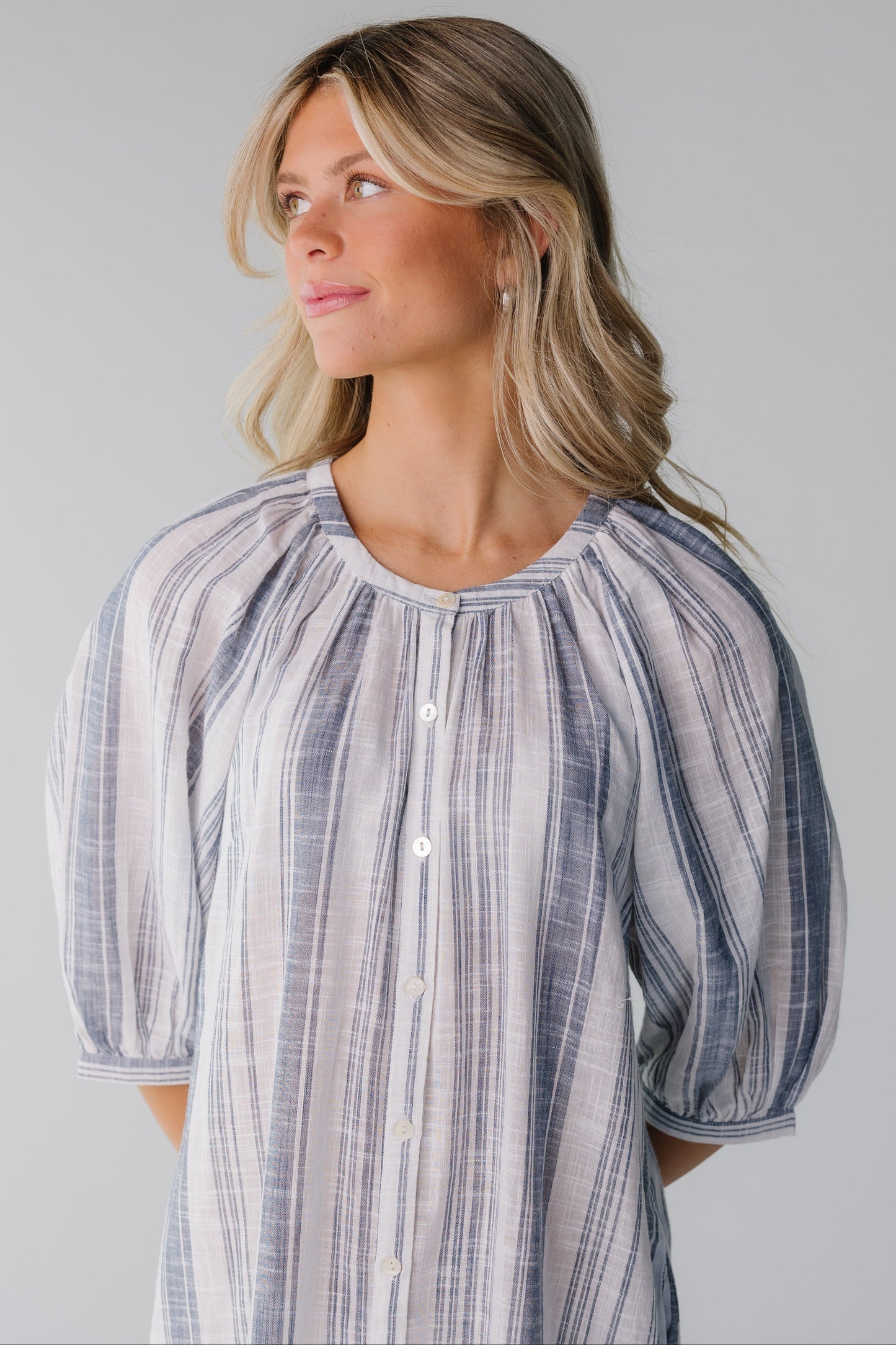 Close up view of blue and white stripe button down dress with longer sleeves