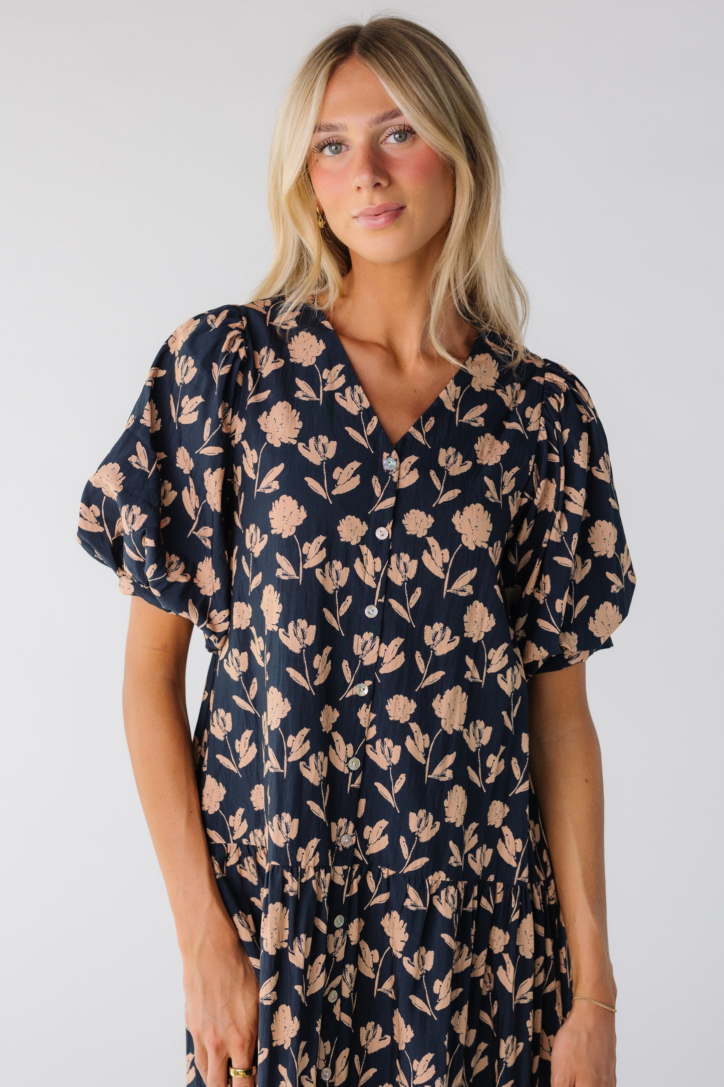 Close view of a woman wearing a navy floral print dress with short sleeves
