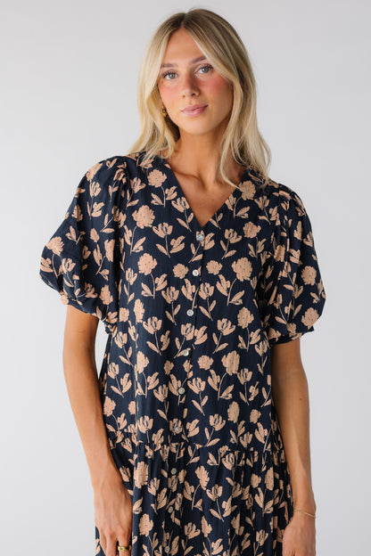 Close view of a woman wearing a navy floral print dress with short sleeves