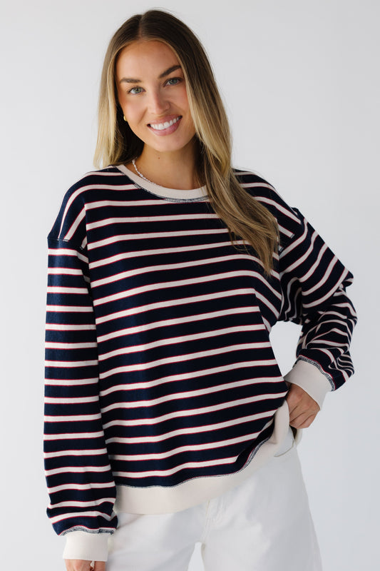 Young woman wearing a navy & white stripe long sleeve pullover with a round crew neckineand rubbed cuffs and waist.
