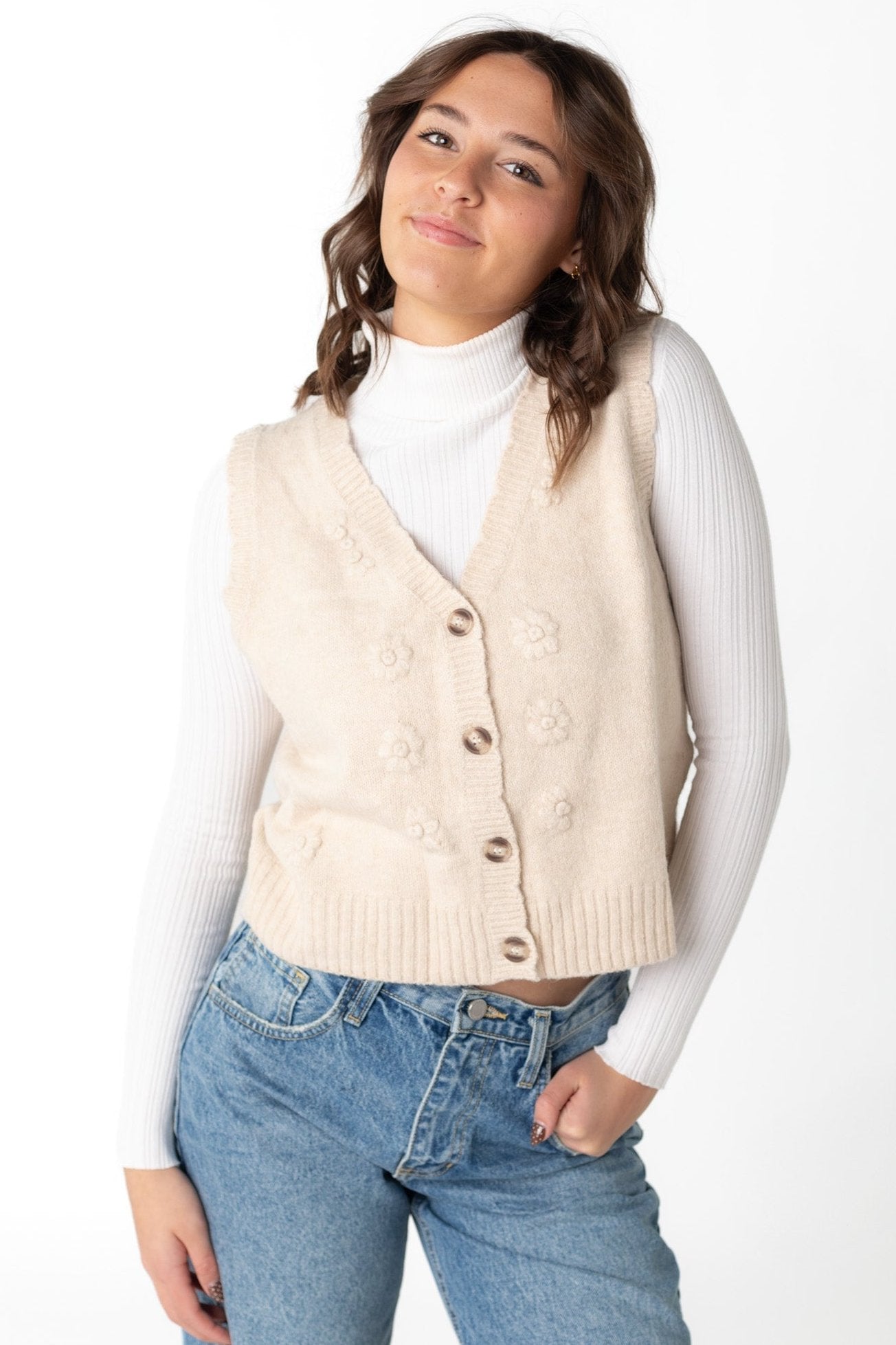 Cream button down sweater vest with V-neckline and same color embroidery details