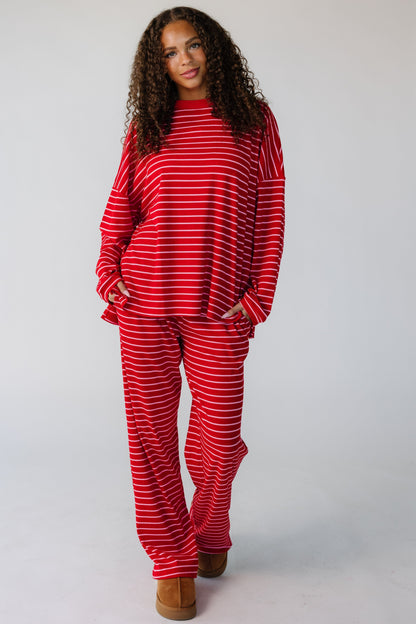 Teen wearing  modest 2 piece lounge set in red with long sleeves and long length pants.