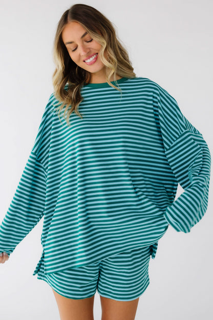 Young woman wearing a loose fitting stripe shorts set in green & blue stripe with long sleeves.