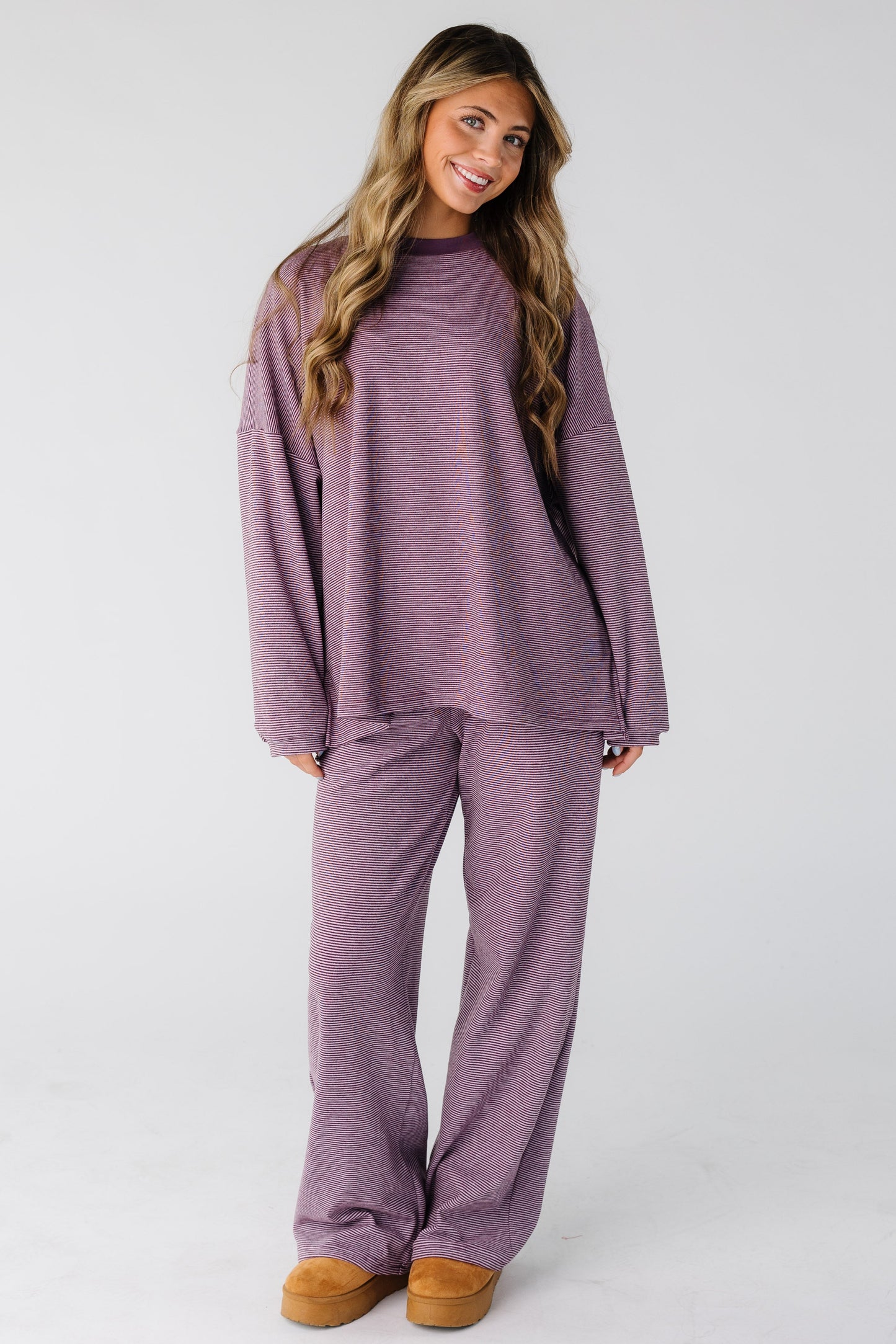 Woman wearing a berry purple 2 piece lounge set with long sleeves and long pants.