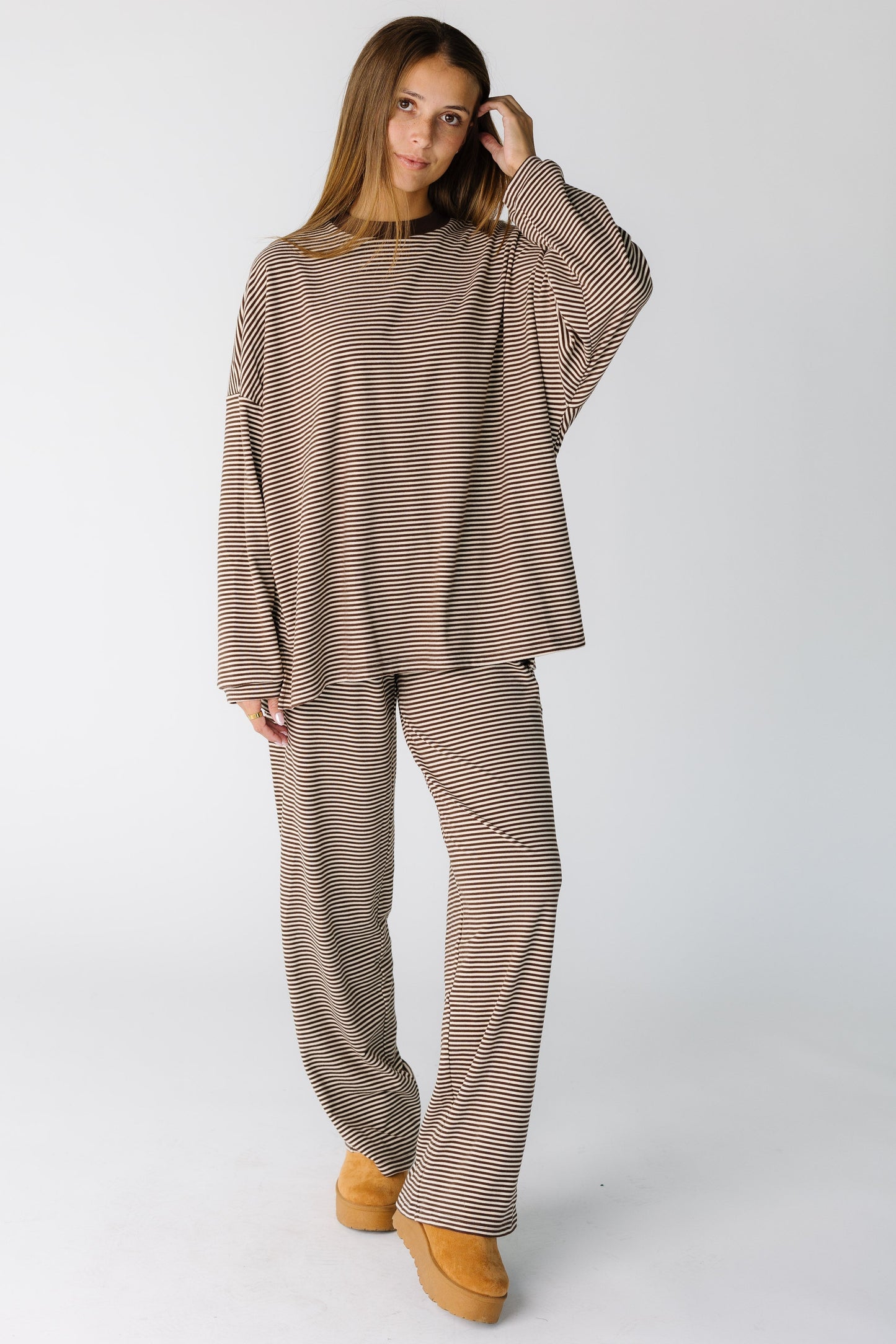 Woman wearing a brown stripe lounge set with drop shoulders and wide cut pant