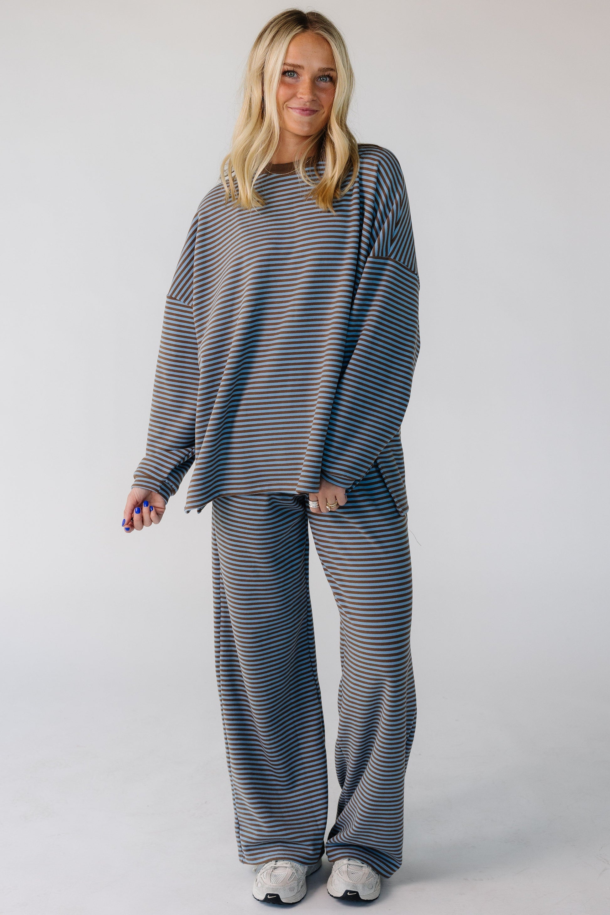 Woman wearing a modest light blue and brown 2 piece lounge set with long sleeves and long length pants.