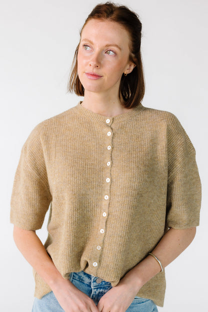 Young woman wearing a button down, rib knit cardigan with short sleeves.