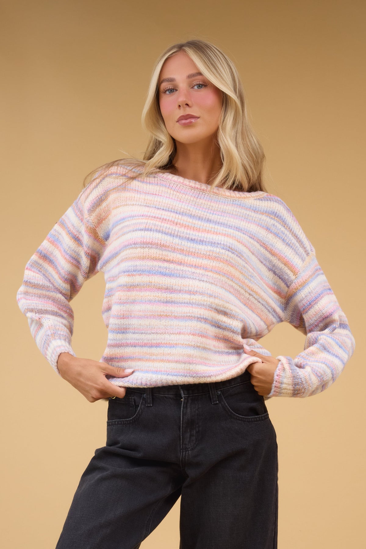 Woman wearing a muted rainbow stripe with long sleeves.