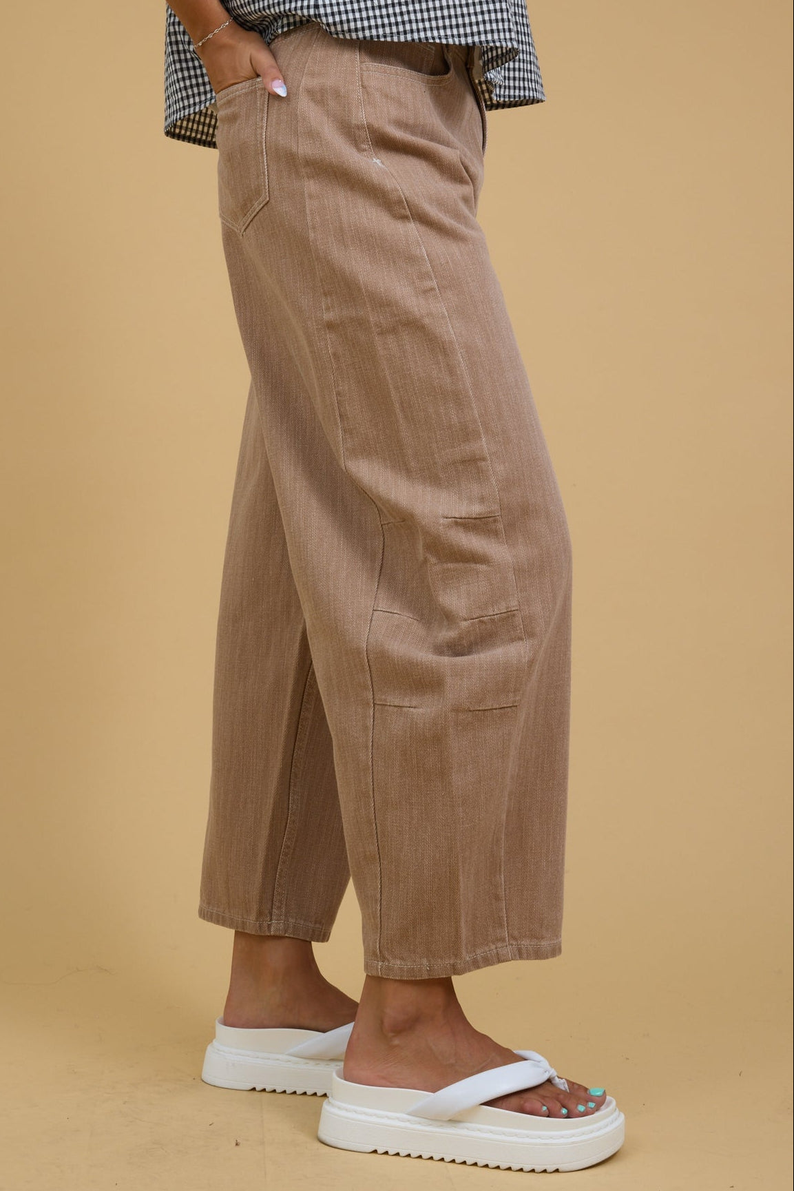 Teenage girl wearing a pair of modest wide leg pants with side panels and pleats.