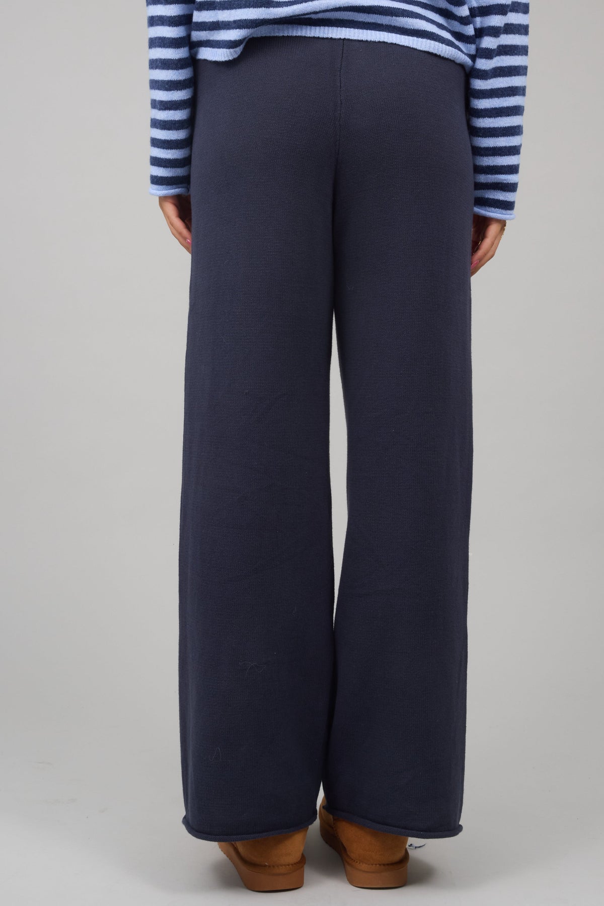 Back view of a woman wearing wide leg navy lounge pants.