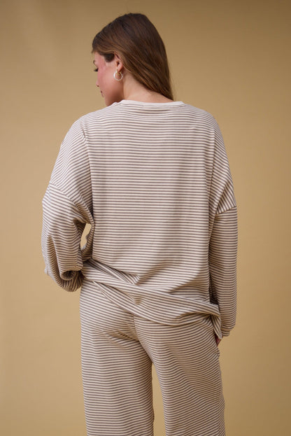 Back view of a woman wearing a loose fitting lounge set with long sleeves.