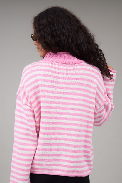 Back view of a woman wearing a pink & white stripe oversized sweater with long sleeves.