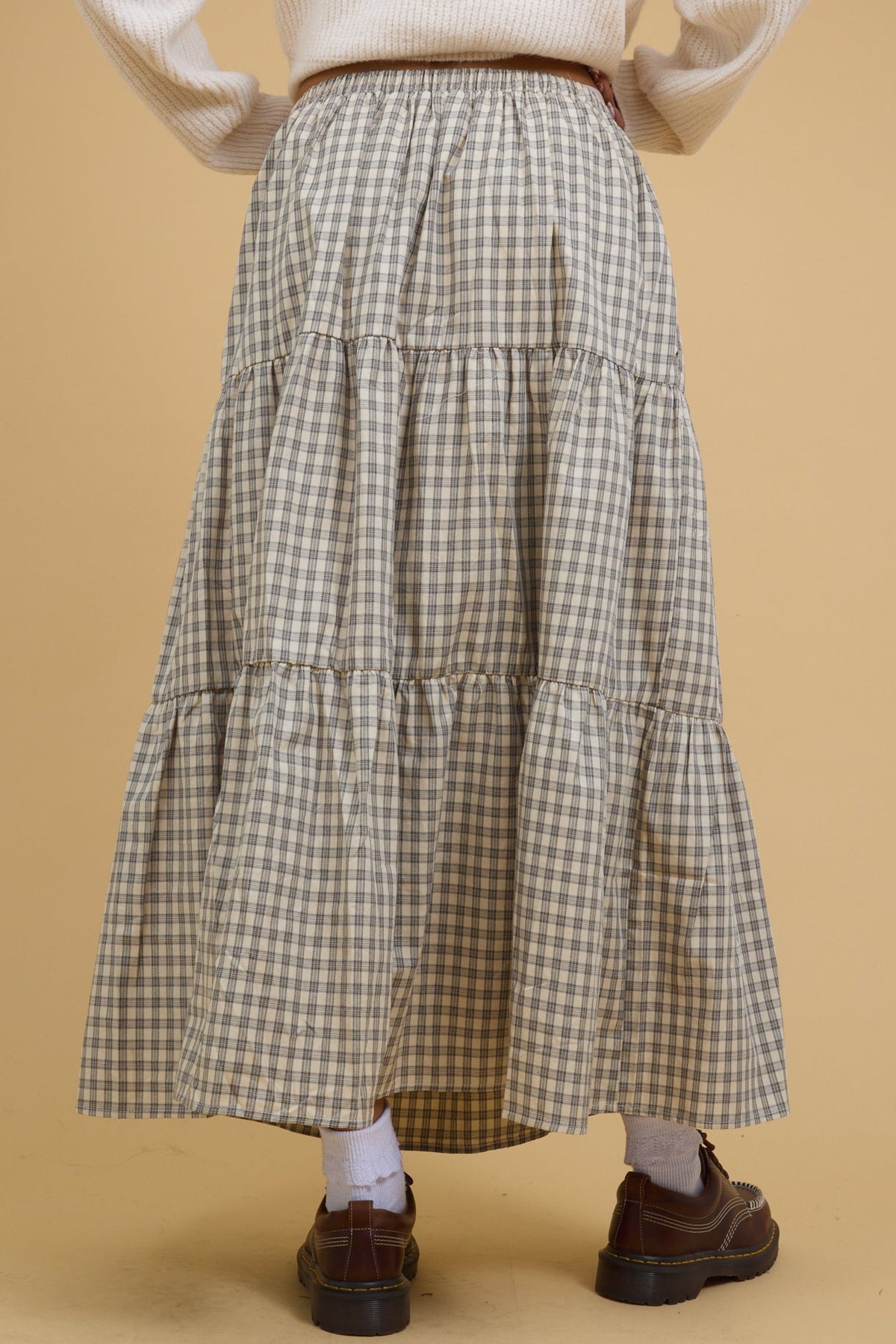 Back view of a teen age girls wearing a midi-maxi tiered skirt.