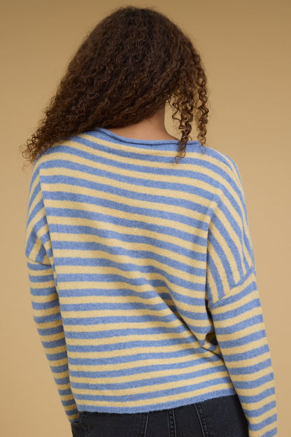 Back view of a woman wearing a yellow and lue stripe pullover with long sleeves.