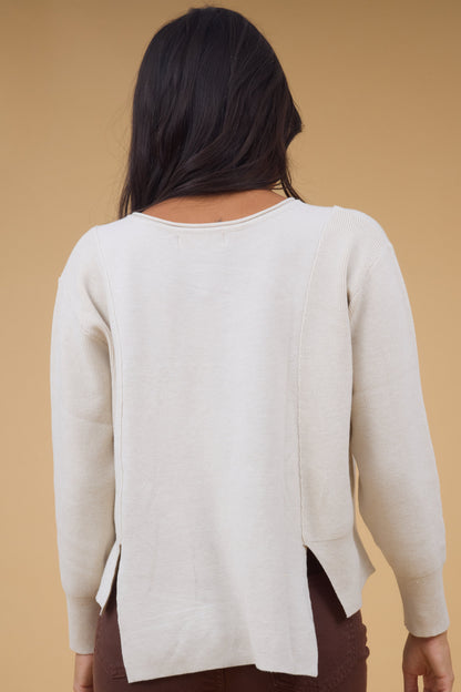 Back view of a woman wearing a 2 fabric knit top with rib side fabrics & sleeves and a smooth center panel.