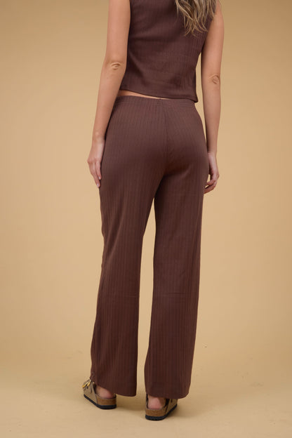 Back view of a woan wearing a pair of brown pointelle knit, wide leg pant.