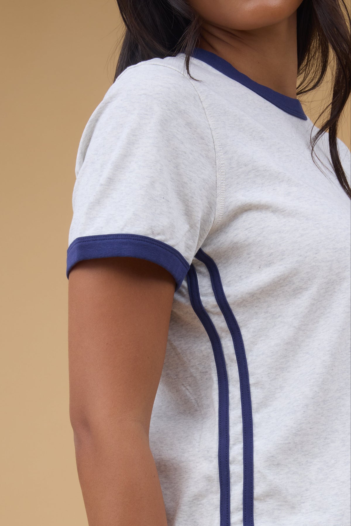 Close view of a woman wearing a grey tee with navy details.