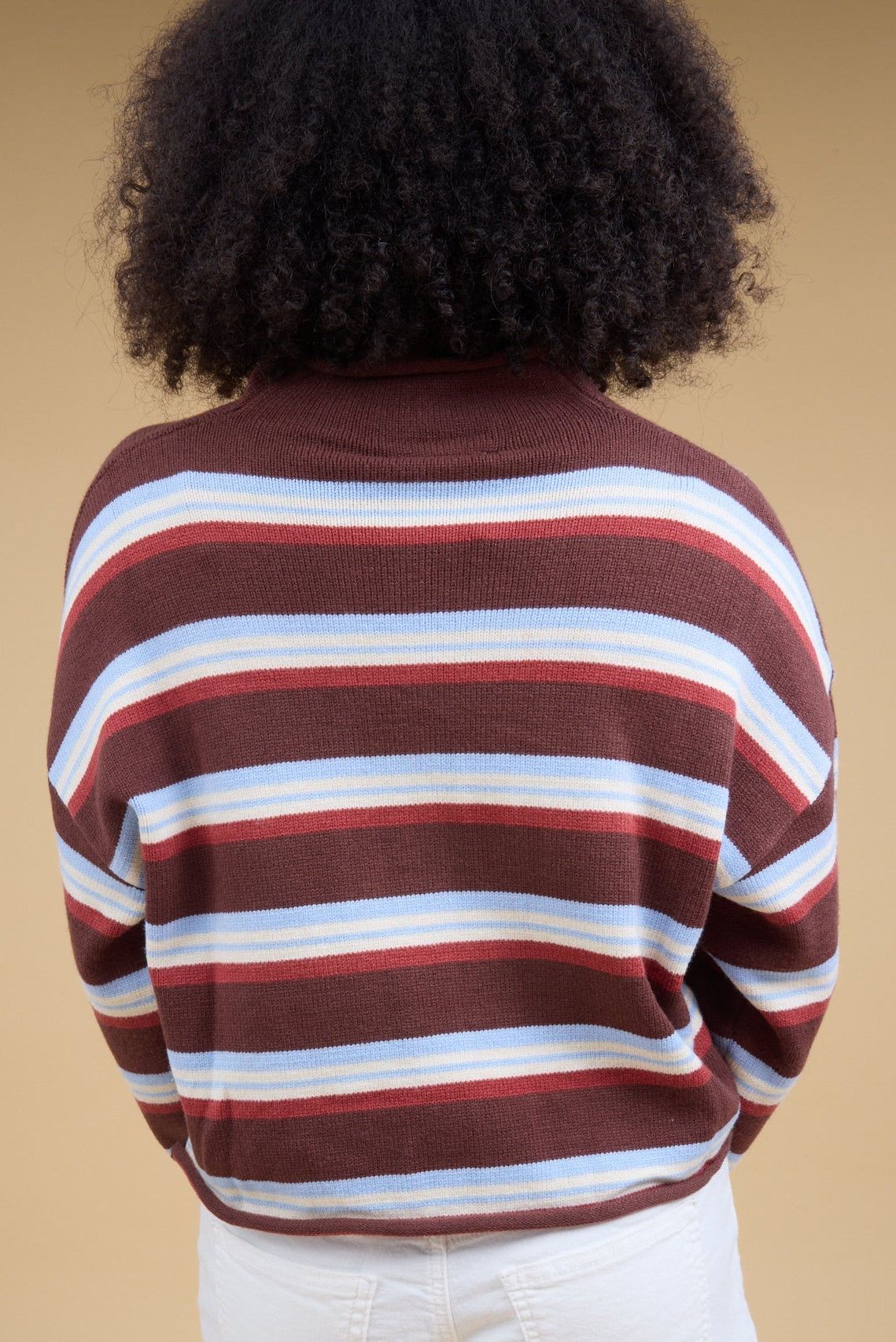 Back view of a woman wearing a brown stripe cardigan with long sleeves.