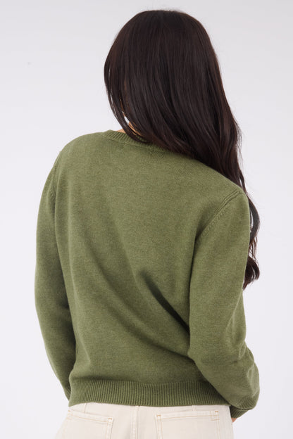 Back view of a woman wearing an olive sweater with long sleeves and a ribbed waistband.