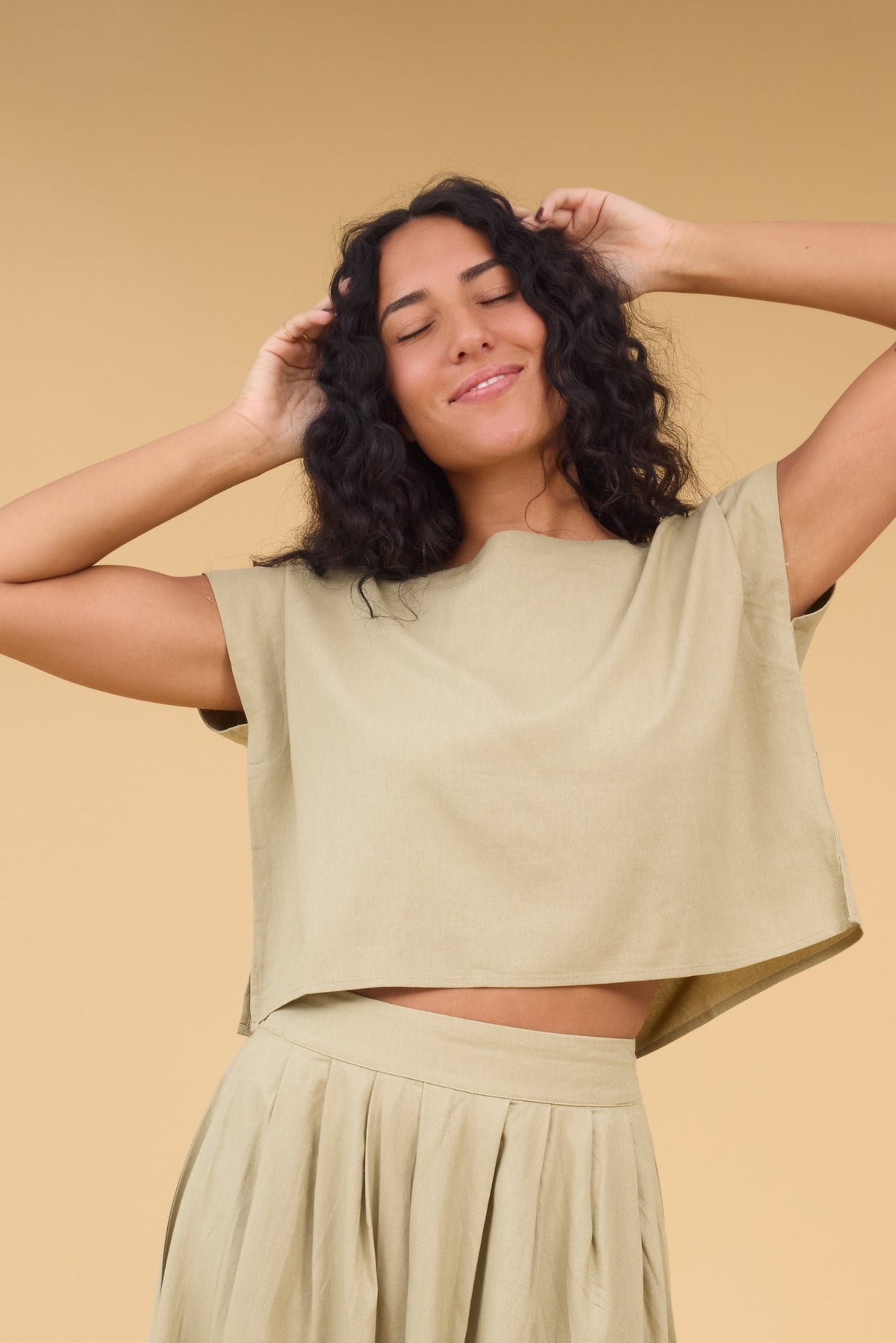 Young woman wearing a loose fitting blouse  with cap sleeves.