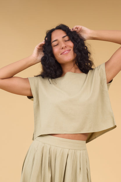 Young woman wearing a loose fitting blouse  with cap sleeves.