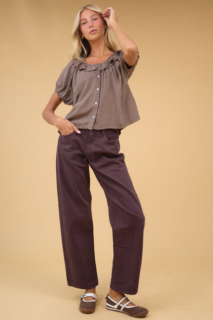 Young woman wearing a pair of wide leg brown jeans with 5 pocktes and zipper/button closure.