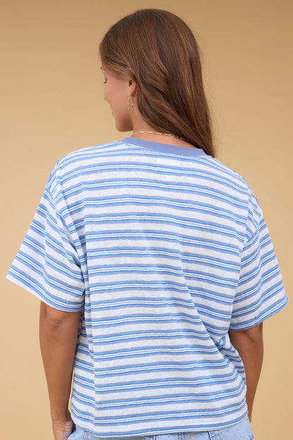 Back view of a woman wearing a white & blue stripe short sleeve tee.