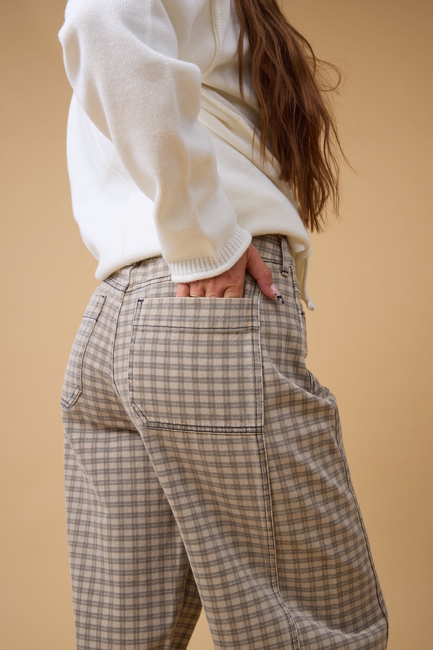 Close view of a woman wearing brown plaid check pant.