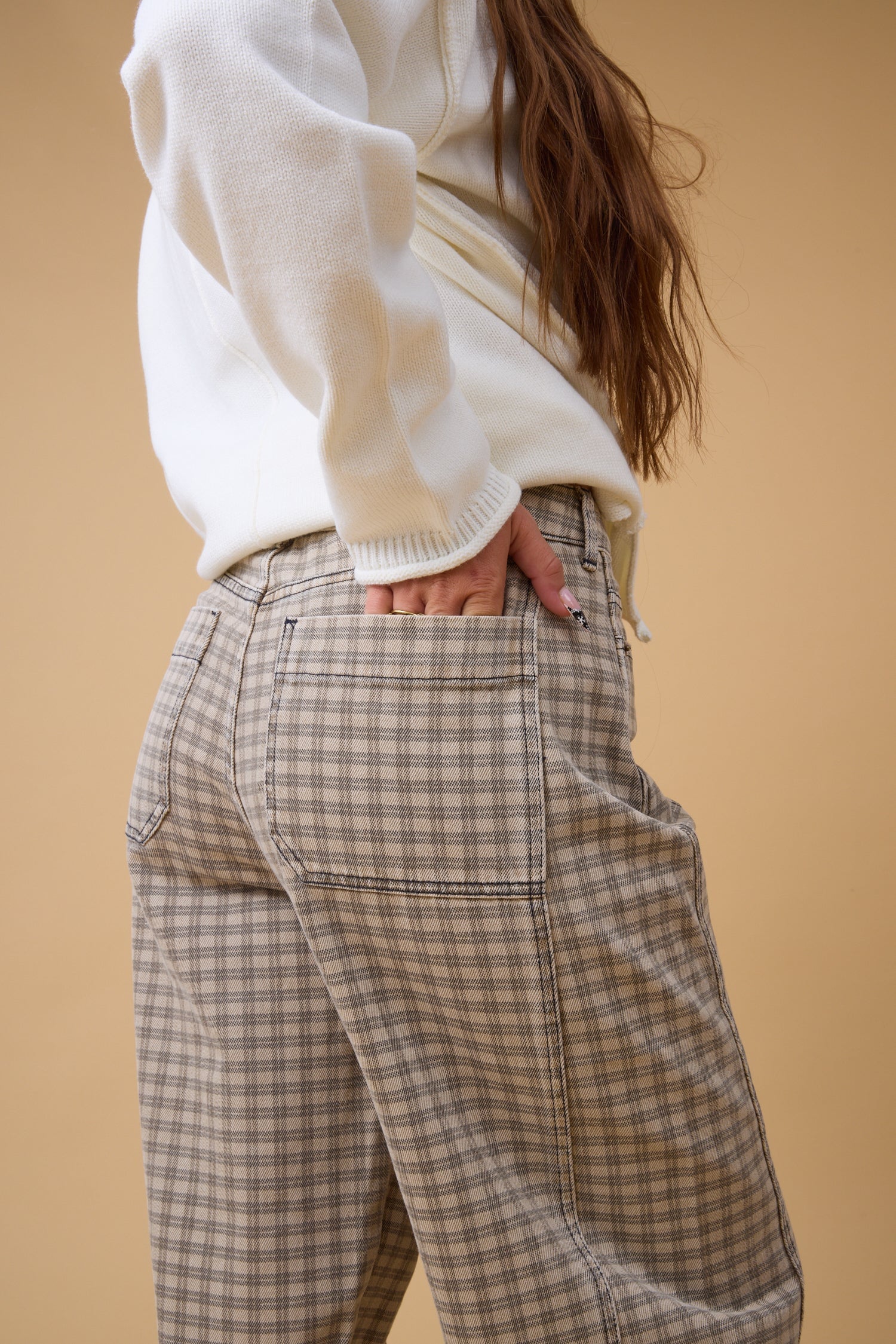 Close view of a woman wearing brown plaid check pant.
