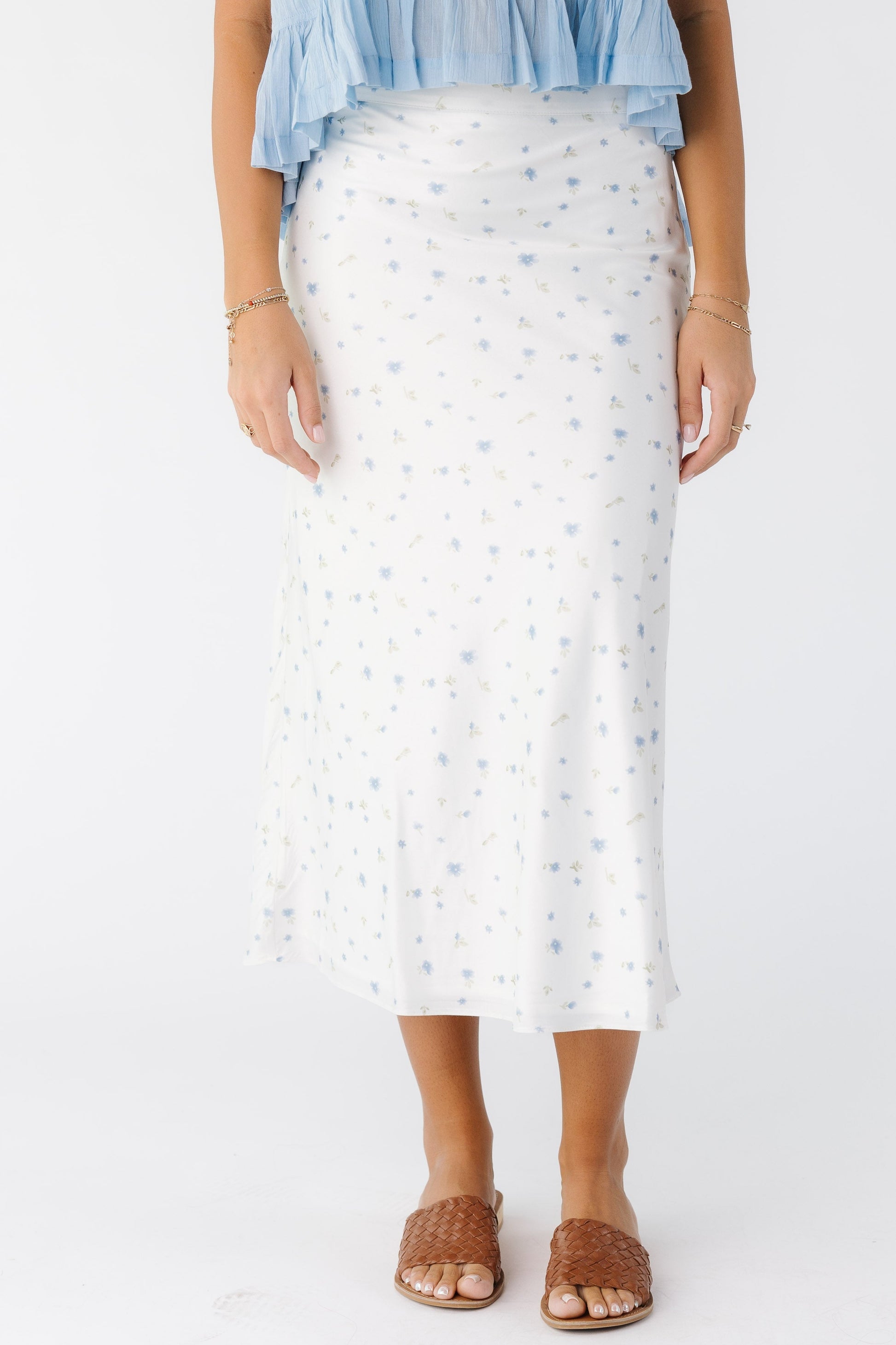 Young woman wearing an off white white and blue floral print, A-line midi skirt.