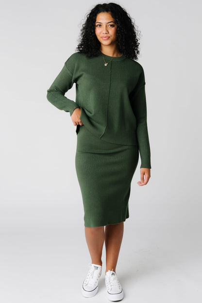 Dark green long sleeve sweater with crew neckline and knee length pencil sweater skirt