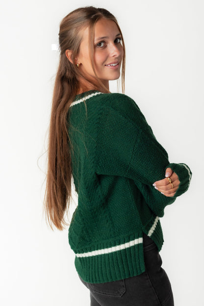 Side view of green cabled sweater with white stripe