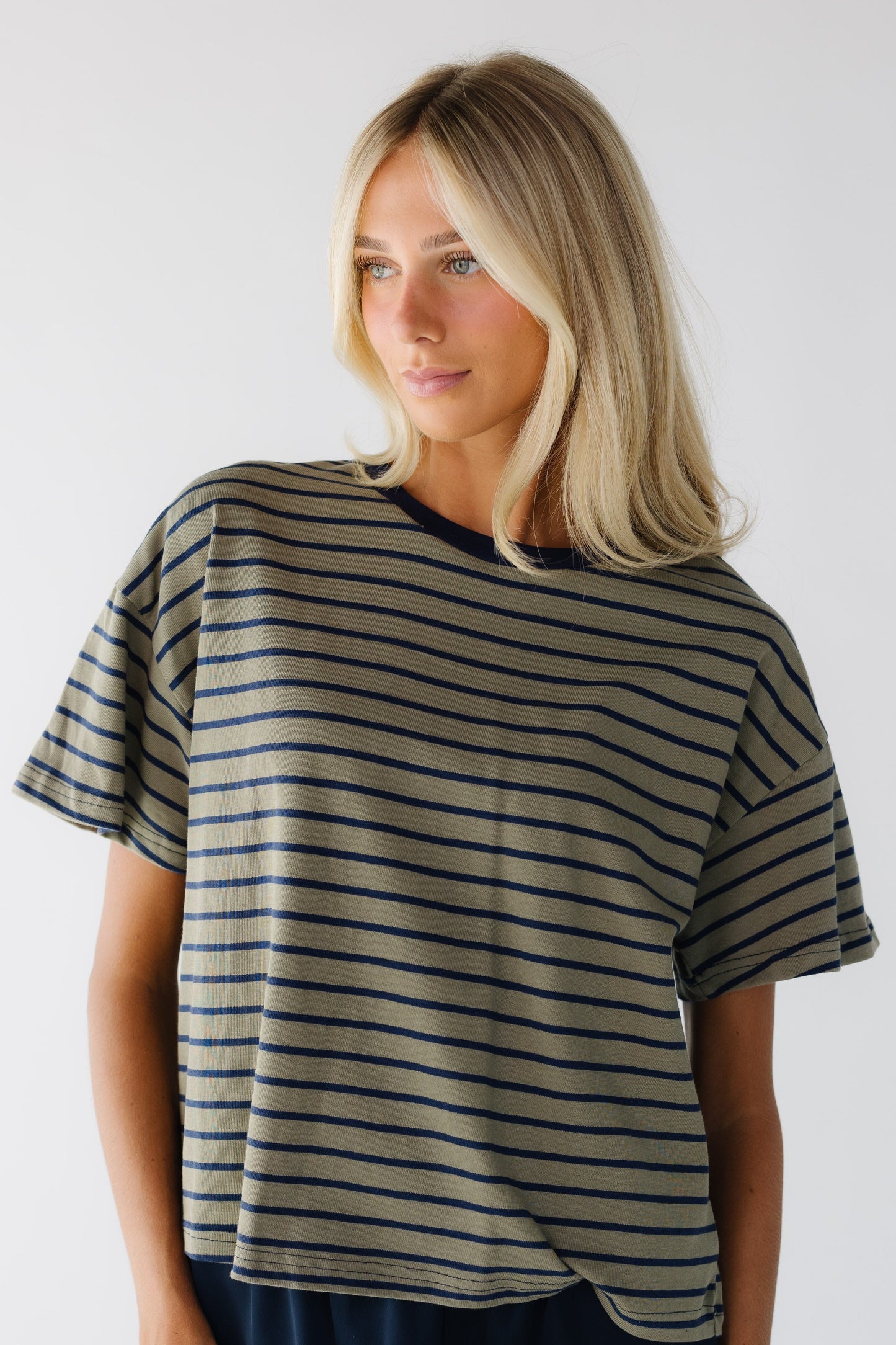 Young woman wearing a modest olive & navy stripe short sleeve tee.
