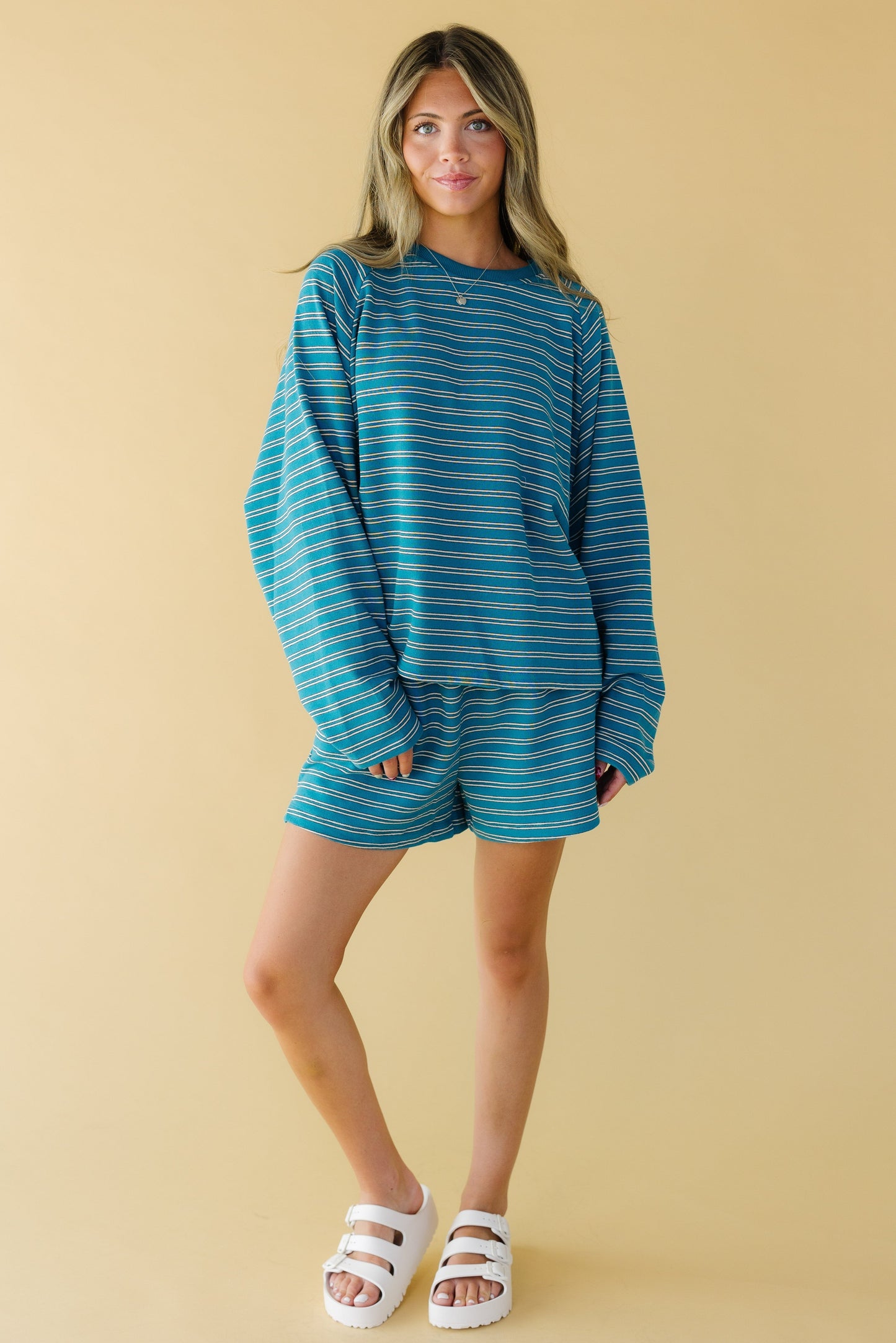 Young woman wearing a loose fitting short set with a loose fitting long sleeve top and wide leg shorts.